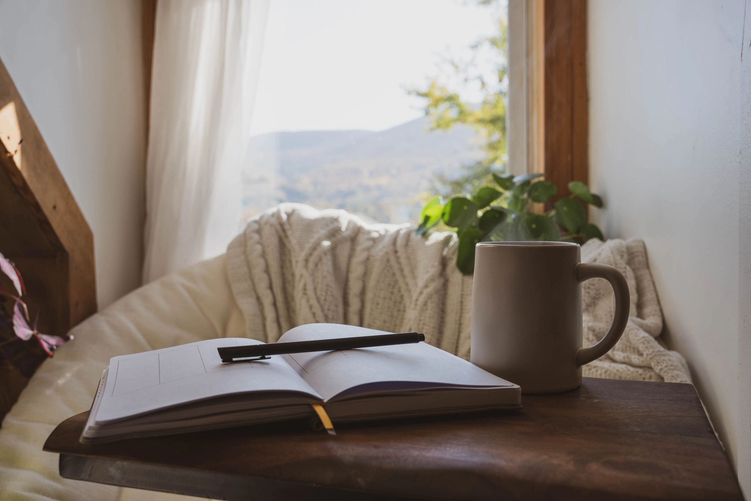 Open journal and warm drink in a calm, cozy space
