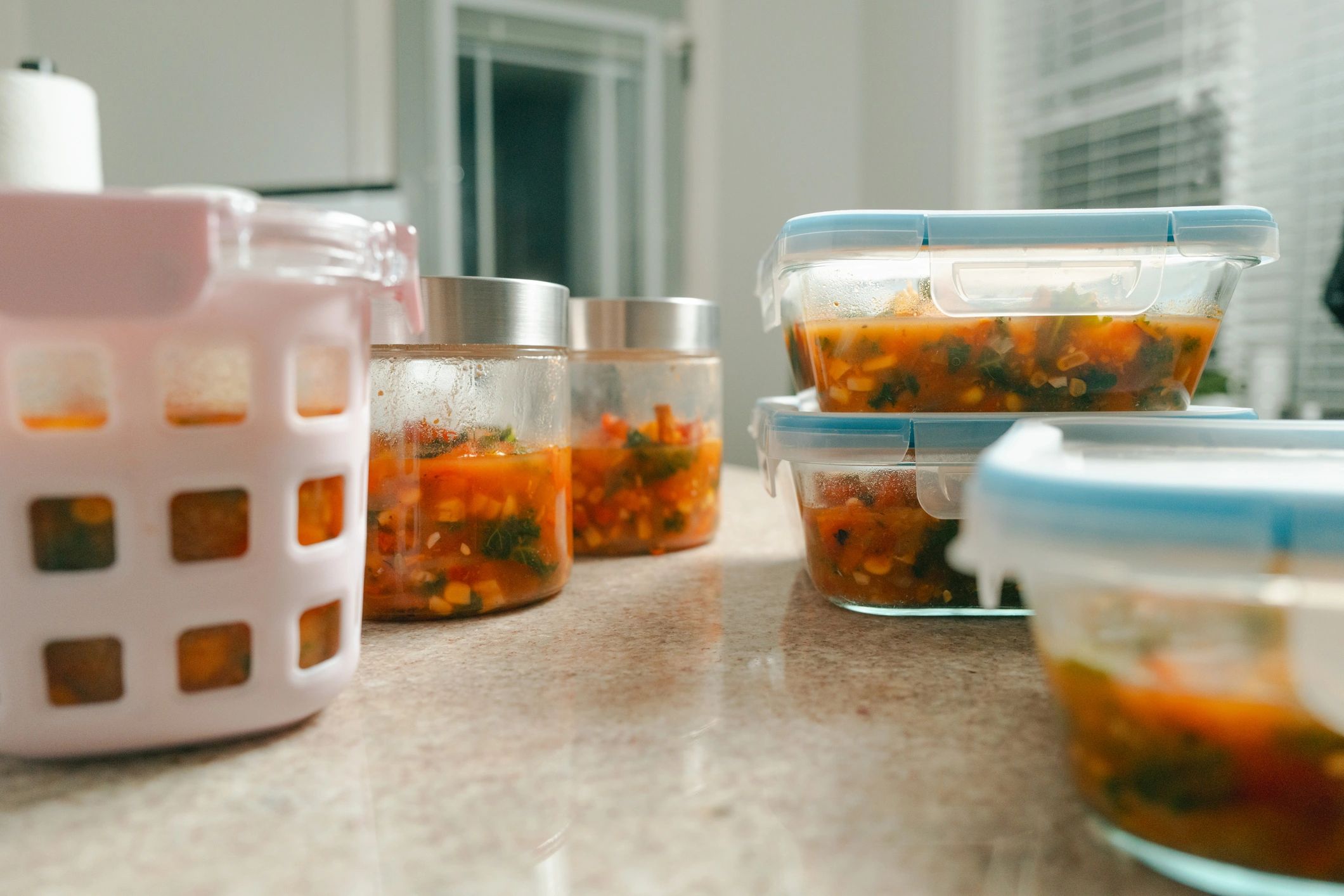Meal prep containers with nourishing soup ingredients representing practical nutrition support