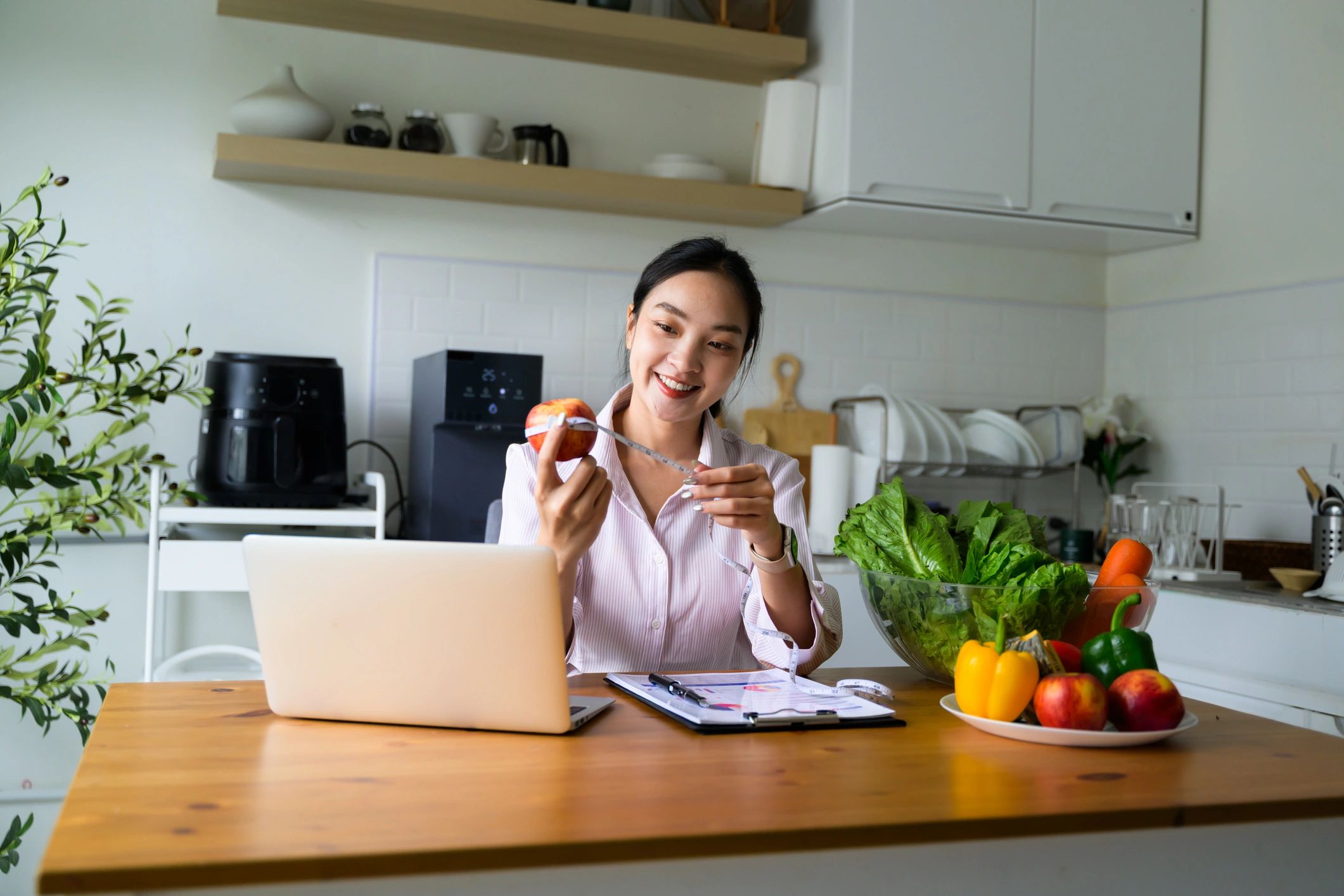 Health coach hosting an online consultation from a bright kitchen
